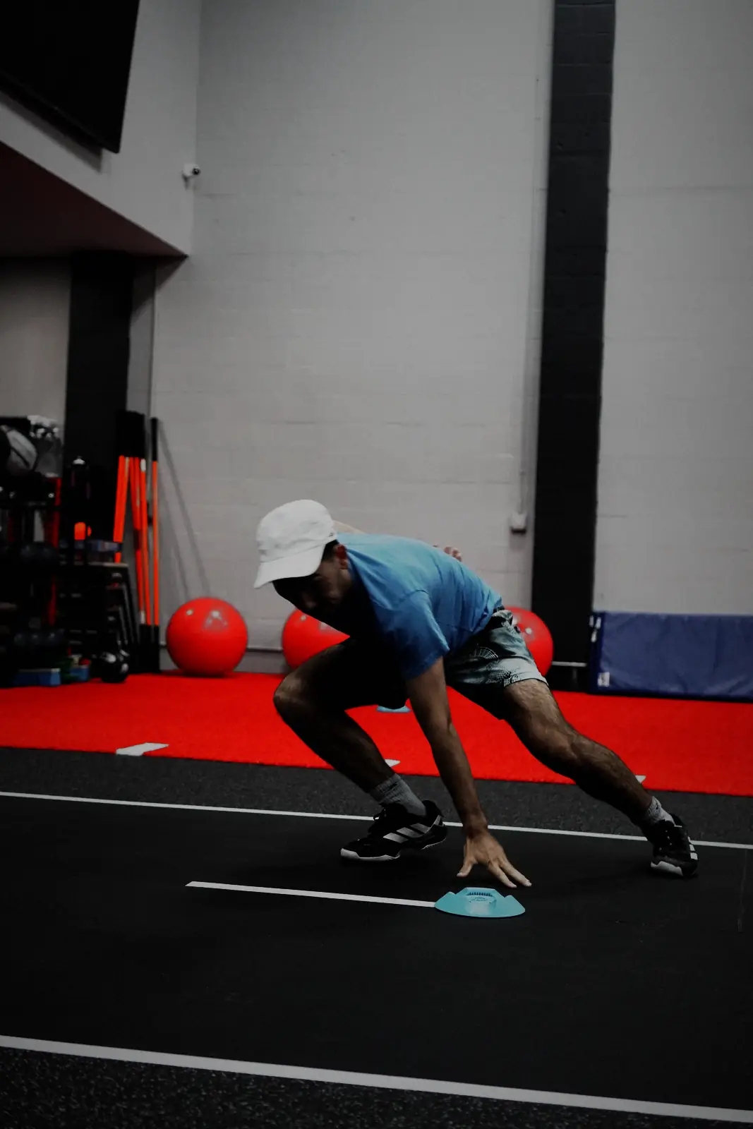 An athlete reaching low through a change-of-direction drill on the track