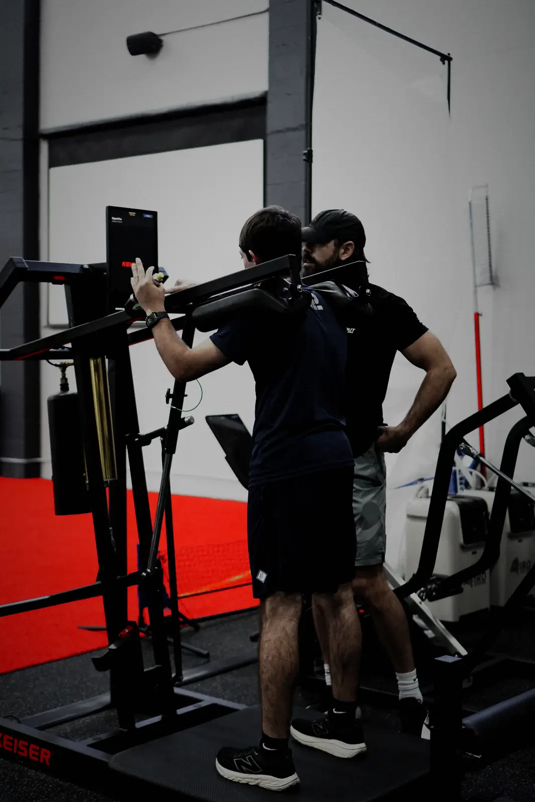A MaxOut360 coach working one-to-one with an athlete on the Keiser