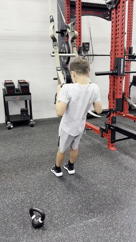 A young athlete doing suspension-strap rows at the rig