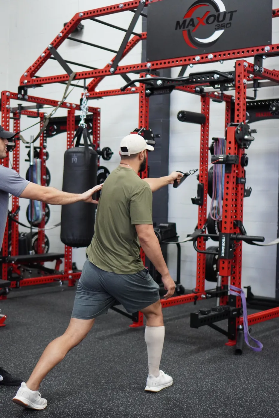 A coach watching an athlete’s cable lunge at the rig
